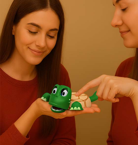 Zwei Frauen betrachten einen 3D-gedruckten Tassenuntersetzer in Form einer grünen Schildkröte. Eine Frau hält die Figur auf der Hand, während die andere mit dem Finger auf den Panzer drückt – ein originelles Geschenk für Geburtstag, Einschulung oder Hochzeit.